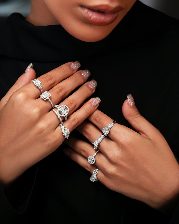 Close-up of a woman's hands displaying multiple elegant diamond rings.